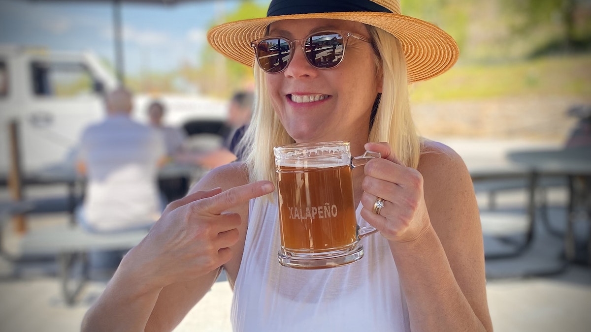 woman drinking beer outside at local brewery in blue ridge ga