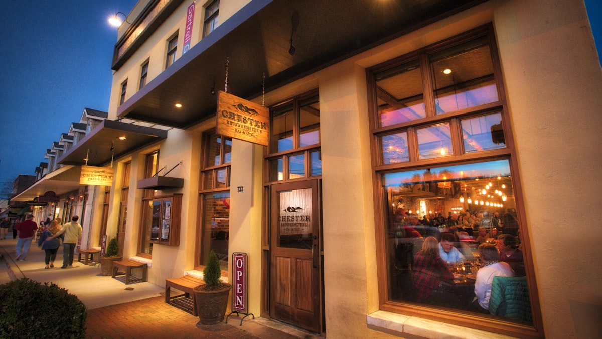 Evening exterior of Chester's with a large window looking into the restaurant filled with patrons